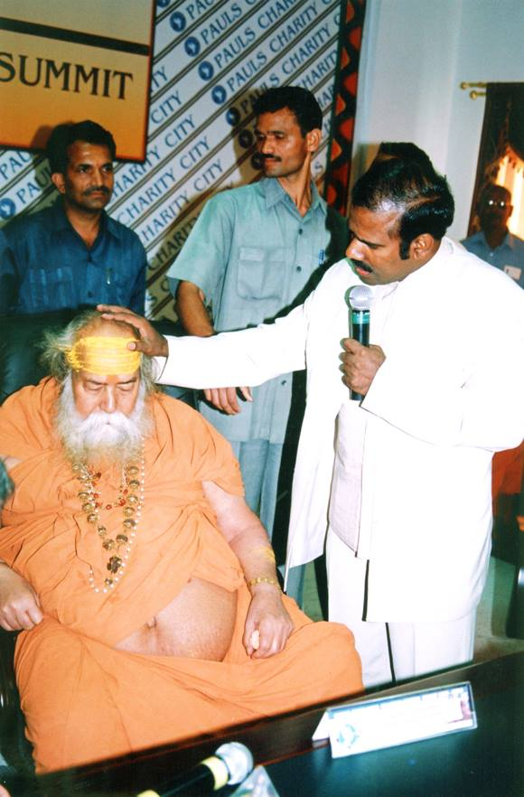 Dr. K.A. Paul praying over a seated Hindu seer during a religious leaders summit